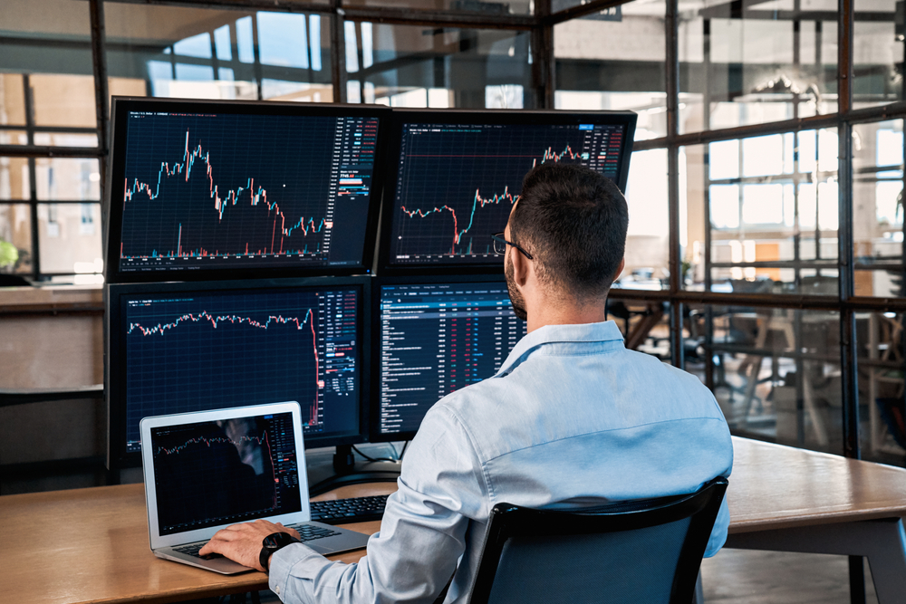 SuccessfulTraderWorkingInModernOfficeLookingAtDisplaySale | Latino Inversores - Inversión y Trading En Línea